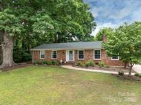 Charming brick home with a landscaped front yard, mature trees, and a welcoming entrance at 3042 Cresthill Dr, Charlotte, NC 28212
