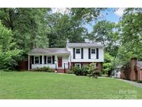 Charming two-story home with manicured lawn, mature trees, and classic black shutters at 3624 Moultrie St, Charlotte, NC 28209