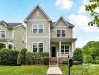 Charming two-story home with manicured lawn, decorative shrubs, and a welcoming front porch at 4732 Water Oak Rd, Charlotte, NC 28211