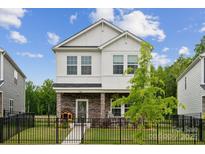 Charming two-story home with stone accents, black fence, and manicured lawn at 500 Cedar Knoll Cir, Pineville, NC 28134