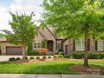 Charming stone home with manicured lawn and mature landscaping at 5805 Copperleaf Commons Ct, Charlotte, NC 28277