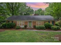 Charming brick home with a well-manicured lawn and mature trees at 5926 Sharon Rd, Charlotte, NC 28210