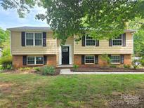 Charming two-story home with a classic facade, black shutters, and manicured landscaping at 7021 Willow Bend Ln, Mint Hill, NC 28227