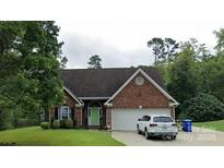 Charming red brick home with a well-manicured lawn and a bright green front door at 7134 Hunters Bluff Dr, Denver, NC 28037