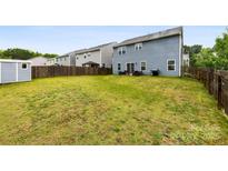 Spacious fenced backyard features a green lawn, storage shed, and patio area at 1022 Hinson Forest Rd, Monroe, NC 28110