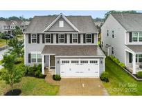 Charming two-story home features a well-manicured lawn, a two-car garage, and stylish gray siding at 1022 Hinson Forest Rd, Monroe, NC 28110