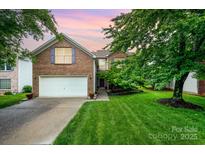 Charming two-story brick home with a well-manicured lawn and attached two-car garage at 116 Amber Woods Dr, Tega Cay, SC 29708
