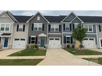Charming townhome featuring well-manicured lawn, single car garage, and colorful front doors at 124 Kristin View Ln # C, Troutman, NC 28166
