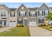 Charming townhome exterior featuring a well-manicured lawn, attached garage, and classic architectural details at 124 Kristin View Ln # C, Troutman, NC 28166