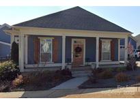 Charming single-story home with a welcoming front porch, wood shutters, and landscaped front yard at 134 Aquinas Way, Rock Hill, SC 29730