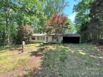 Charming single-story home with a covered carport nestled amongst mature trees on a wooded lot at 1399 Branton Dr, Iron Station, NC 28080