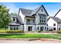 Charming home with a well-manicured front lawn, stone accents, and a mix of board and batten and stucco exterior at 14105 Ryker Way, Davidson, NC 28036
