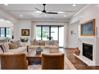 Bright living room featuring coffered ceiling, hardwood floors, a fireplace, and sliding glass doors to the exterior at 14105 Ryker Way, Davidson, NC 28036