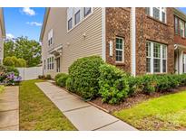 Charming exterior showcasing a well-maintained home with a combination of brick and siding, lush landscaping, and a welcoming walkway at 18339 The Commons Blvd, Cornelius, NC 28031