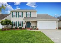 Charming two-story home with a well-manicured lawn, complemented by lush landscaping and a two-car garage at 2018 Rosewater Ln, Indian Trail, NC 28079