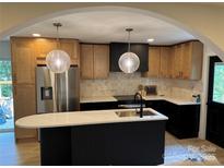 An open kitchen with modern appliances, a large island, and stylish pendant lighting is seen at 3326 Winterfield Pl, Charlotte, NC 28205