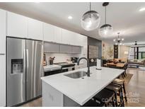 Modern kitchen features stainless steel appliances, a large island, and stylish lighting at 4520 Radler Ct, Charlotte, NC 28217