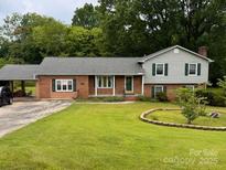 Charming two-story home with brick accents, a well-manicured lawn, and mature trees in a serene, wooded setting at 6561 Weldon Nw Cir, Concord, NC 28027