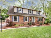 Charming two-story brick home with blue shutters and manicured lawn offering timeless appeal at 6941 Queensberry Dr, Charlotte, NC 28226