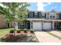 Charming two-story townhome featuring an attached one-car garage and a well-manicured front yard at 7024 Jane Parks Way, Charlotte, NC 28217