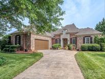 Charming brick and stone home featuring a lush lawn, decorative shutters and a well-manicured front yard at 705 Woburn Abbey Dr, Fort Mill, SC 29715