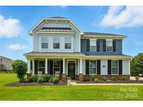 Charming two-story home features a covered front porch, manicured lawn, and craftsman details at 7322 Vesper Dr, Huntersville, NC 28078