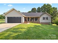 Charming single-story home with a well-manicured lawn and welcoming front porch at 105 Saddlewood Ln, Statesville, NC 28625