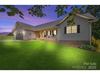 Charming home with lush green lawn, inviting front porch, and a two-car garage offers curb appeal at 105 Saddlewood Ln, Statesville, NC 28625