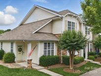 Charming townhome featuring stone accents, a welcoming front door, and a well-maintained lawn and landscaping at 1061 Woodglen Ln, Matthews, NC 28104