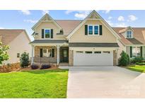 Charming two-story home with a well-manicured lawn, a brick porch, and an attached two-car garage at 1280 Winged Foot Dr, Denver, NC 28037