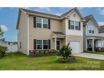Charming two-story home with neutral siding, dark shutters, manicured lawn, and a one-car garage at 13022 Hill Pine Rd, Midland, NC 28107