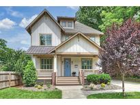 Charming two-story home featuring a welcoming front porch, complemented by lush landscaping and a beautifully maintained lawn at 1315 Charles Ave, Charlotte, NC 28205