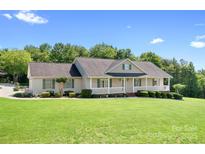 Charming single-story home featuring a welcoming front porch and beautifully landscaped front yard at 136 Barringer Dr, Statesville, NC 28625