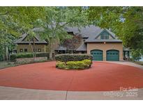 Stunning two-story home featuring a circular driveway, three-car garage and lush landscaping at 145 Hunters Pointe Ln, Mooresville, NC 28117