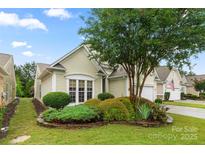 Charming home exterior featuring a well-manicured lawn and landscaped garden beds with a mature tree at 15152 Legend Oaks Ct, Indian Land, SC 29707