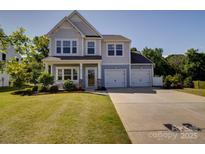 Charming two-story home with a well-manicured lawn and a spacious two-car garage at 2035 Beacon Ave, Monroe, NC 28110