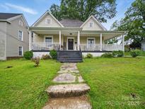 Charming house featuring a welcoming front porch, complemented by a well-maintained lawn and inviting walkway at 211 S Rowan Ave, Spencer, NC 28159