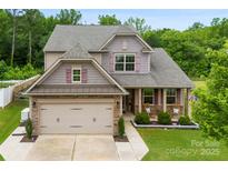 Charming two-story home with a two-car garage, covered porch, and well-maintained landscaping at 225 Tasman Dr, Mount Holly, NC 28120