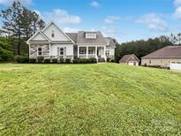 Charming two-story home featuring stone accents, white siding, manicured landscaping and a lovely covered front porch at 263 Lauren Pines Dr, York, SC 29745