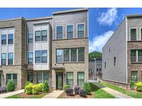 Attractive exterior view of a new townhome featuring brick and gray siding with manicured landscaping at 3722 Ellington St, Charlotte, NC 28211