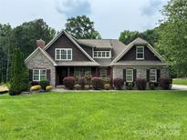 Charming stone and shingle home with lush landscaping and well-manicured lawn at 5164 Mill Race Ln, Lancaster, SC 29720