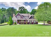 Charming two-story home with manicured lawn, mature trees, and stone accents at 5164 Mill Race Ln, Lancaster, SC 29720