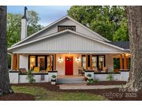 Charming home featuring a covered porch with inviting seating and a vibrant red front door at 606 1St W St, Conover, NC 28613