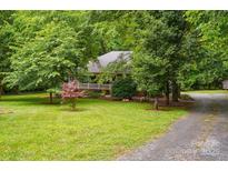 Well-maintained front yard and covered porch offer curb appeal to this charming home at 7725 Whitmire Ln, Mint Hill, NC 28227