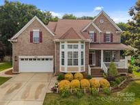 Charming brick home with well-manicured landscaping and inviting front porch, plus a two-car garage at 10703 Back Ridge Rd, Charlotte, NC 28277