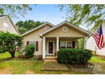 Charming single-story home with manicured lawn, covered porch, and classic architectural details under a clear blue sky at 122 Pratt St, Belmont, NC 28012