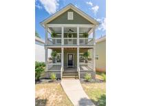 Charming two-story home featuring a double porch, garden beds, and stylish architectural details at 12220 Huntersville Concord Rd, Huntersville, NC 28078