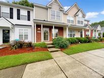 Charming townhouse showcasing well-manicured lawn and inviting front porch at 14123 Tranters Creek Ln, Charlotte, NC 28273