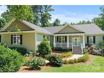 Charming home featuring a covered front porch, manicured landscaping, and a well-maintained lawn at 1819 Brompton Ct, Newton, NC 28658