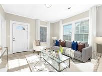 Bright living room with large windows, modern gray couch and stylish decor at 210 E 5Th Ave, Gastonia, NC 28054